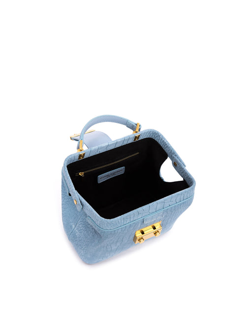 Angled over head view of wide open Elizabeth Doctor Bag in blue croc suede with open leather handle brass clasp buckle
