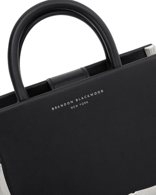 Angled close up Bamboo B Tote in black leather with leather handle and silver bamboo embossed trim