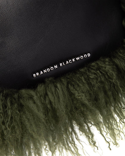 Angled close up of Cortni Bag in black leather with green wool brandon blackwood logo hardware thumbnail 3