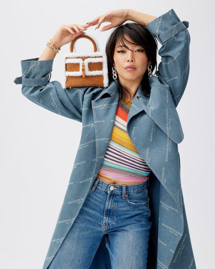 model posing with  Kuei Bag in tan suede with shearling edges with suede zipper  thumbnail 2