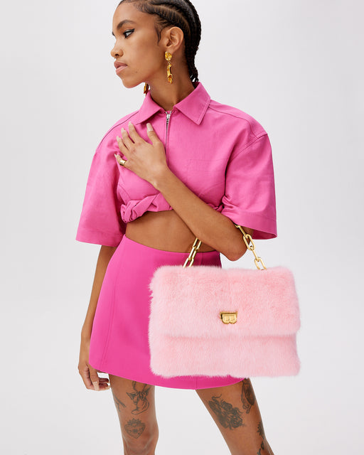 Model posing with  Lisa Shoulder Bag in pink mink with brass chain link handle and B logo closure