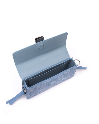 Angled over head view of wide open Nia Bag with blue croc embossed suede and blue suede strap with silver logo magnetic closure thumbnail 2