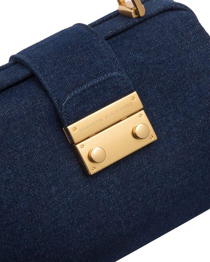 Angled close up of Elizabeth Doctor Bag in dark denim with brass clasp buckle with embossed logo thumbnail 3