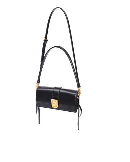 Nia Bag with black hard leather with black leather strap with brass logo magnetic closure hanging from strap thumbnail 5