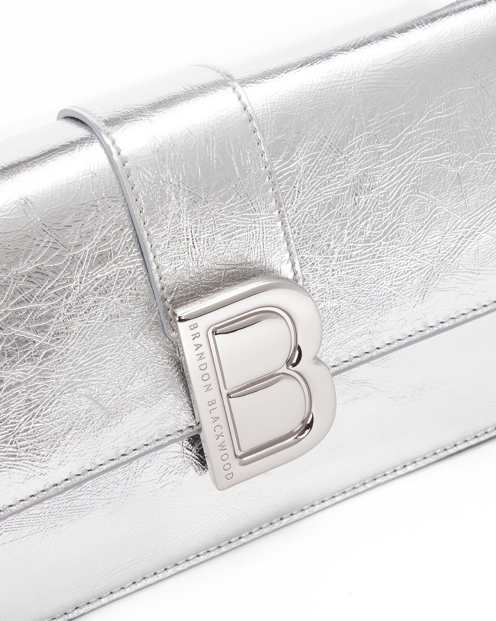 Angled close up of Nia Bag with silver cracked leather with silver logo magnetic closure 