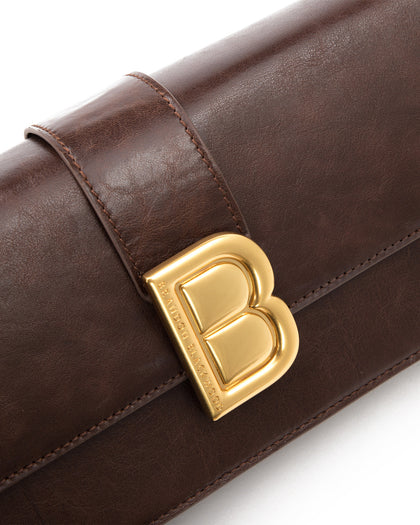 Angled close up of Nia Bag with brown cracked leather with brass logo magnetic closure  thumbnail 3