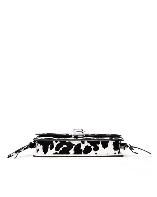 Bottom of Nia Bag with  black and white cow print four metal feet
