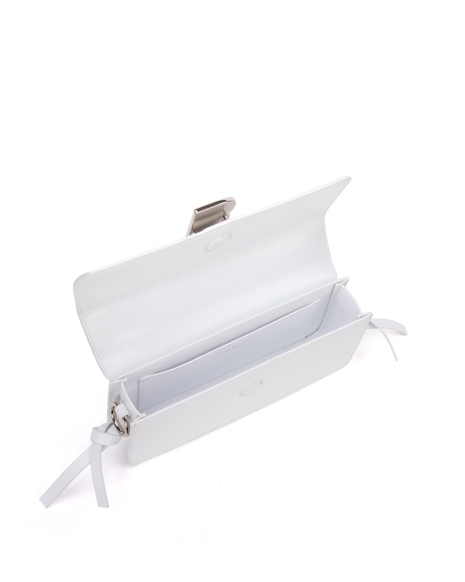 Angled over head view of wide open Nia Bag with white leather and white leather strap with silver  logo magnetic closure