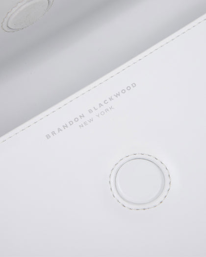 Angled close up of Nia Bag with white hard leather with silver logo magnetic closure  thumbnail 5