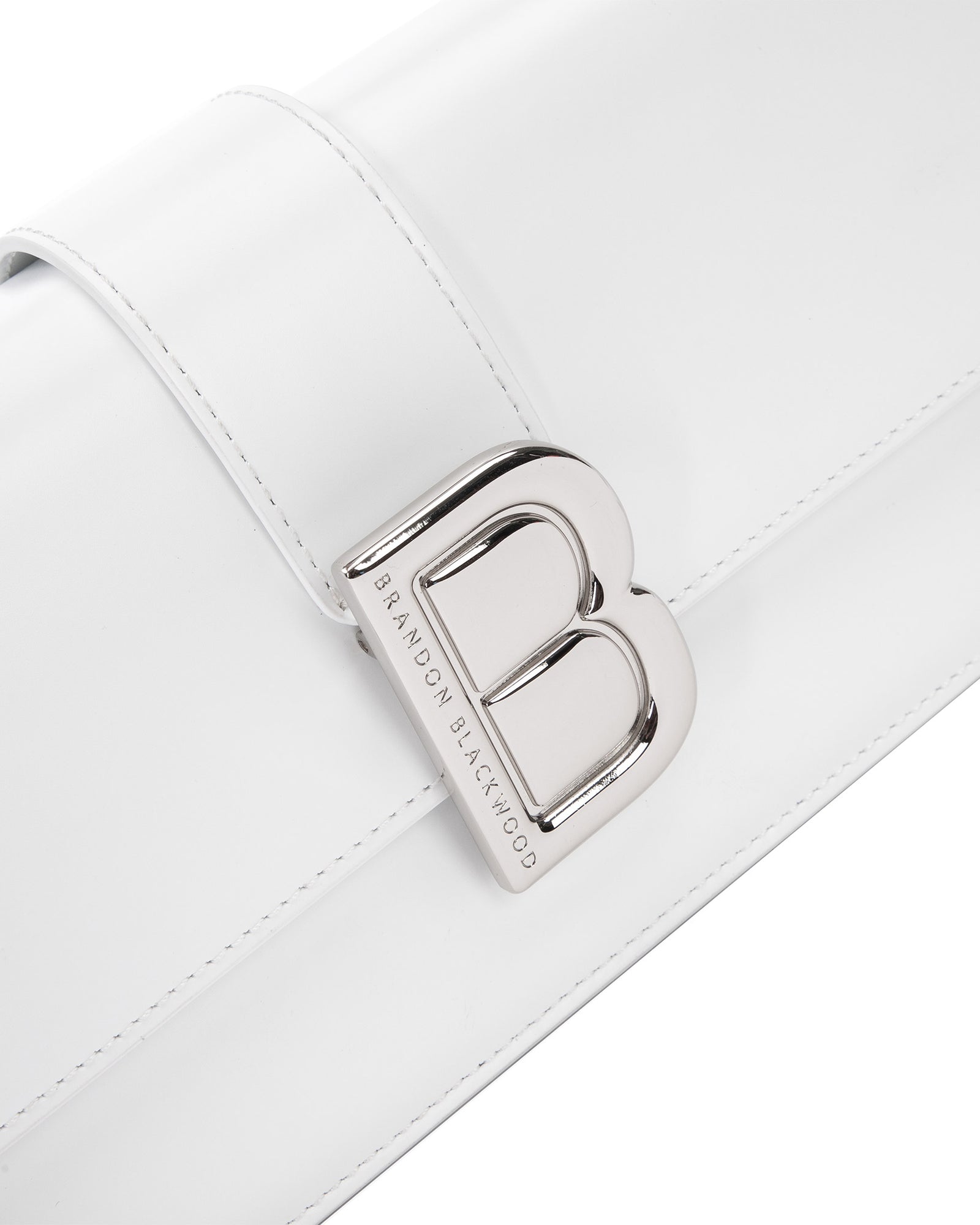 Angled close up of Nia Bag with white hard leather with silver logo magnetic closure 