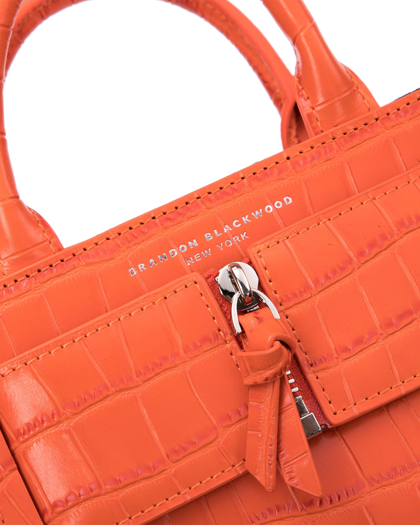 Angled close up of Kuei Bag in orange croc embossed leather