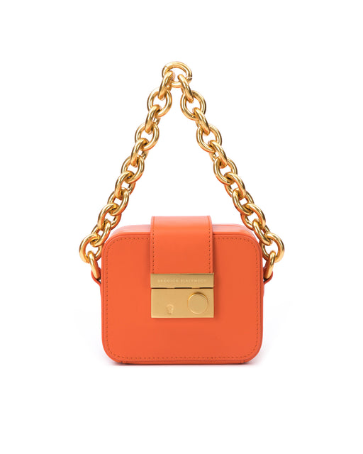 Front of Caro Buckle Bag in burnt orange leather with brass chunky chain handle and brass clasp buckle 