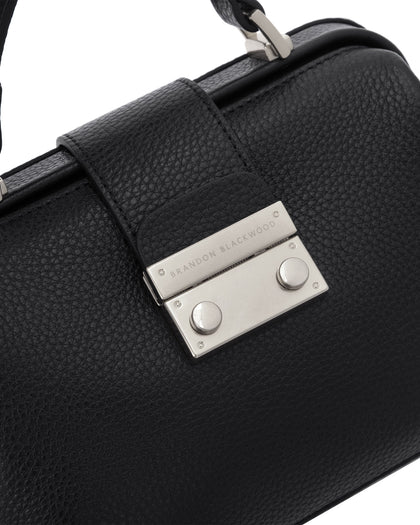 Angled close up of Elizabeth Doctor Bag in black leather with brass clasp buckle with embossed logo thumbnail 3