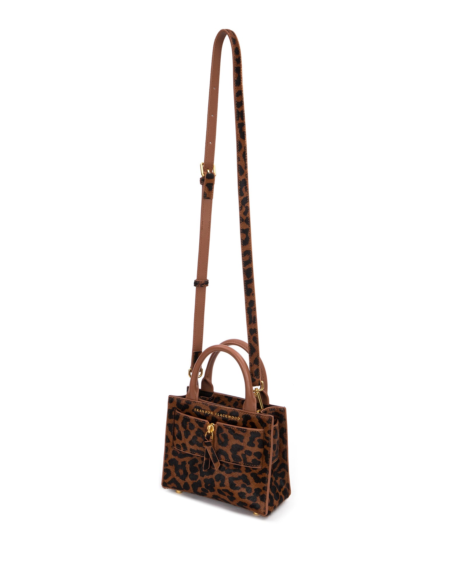 Angled over head view of wide open Kuei Bag in brown and black leopard print ponyhair  with ponyhair handle ponyhair brass zipper hanging from strap