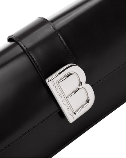 Angled close up of Nia Bag with black hard leather with silver logo magnetic closure  thumbnail 3