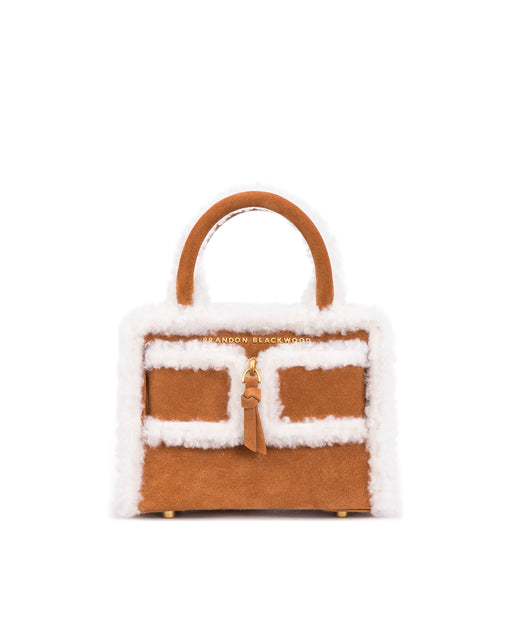 Front of Kuei Bag in tan suede with shearling edges with suede zipper 