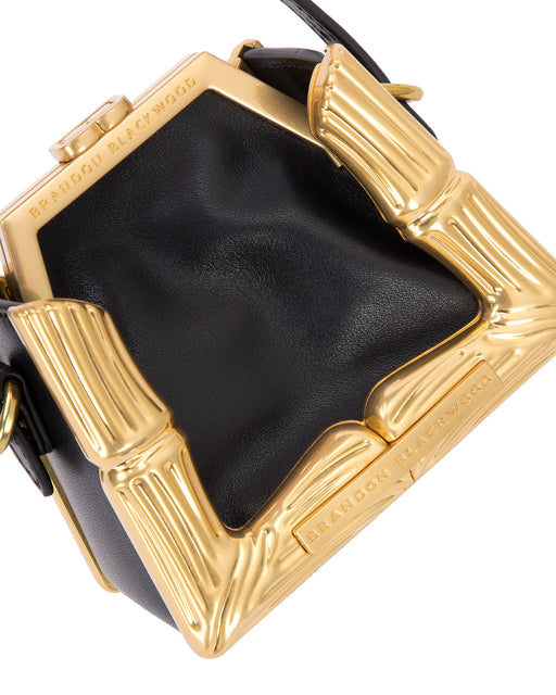 Angled close up Bamboo B Micro Tote in black leather with leather handle and brass bamboo embossed trim